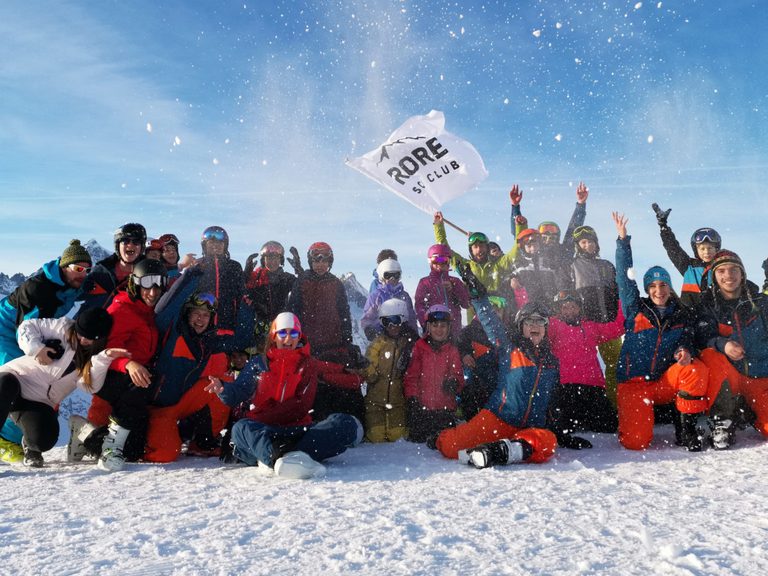 Il gruppo dello Sci Club in posa sulla neve con la bandiera del club